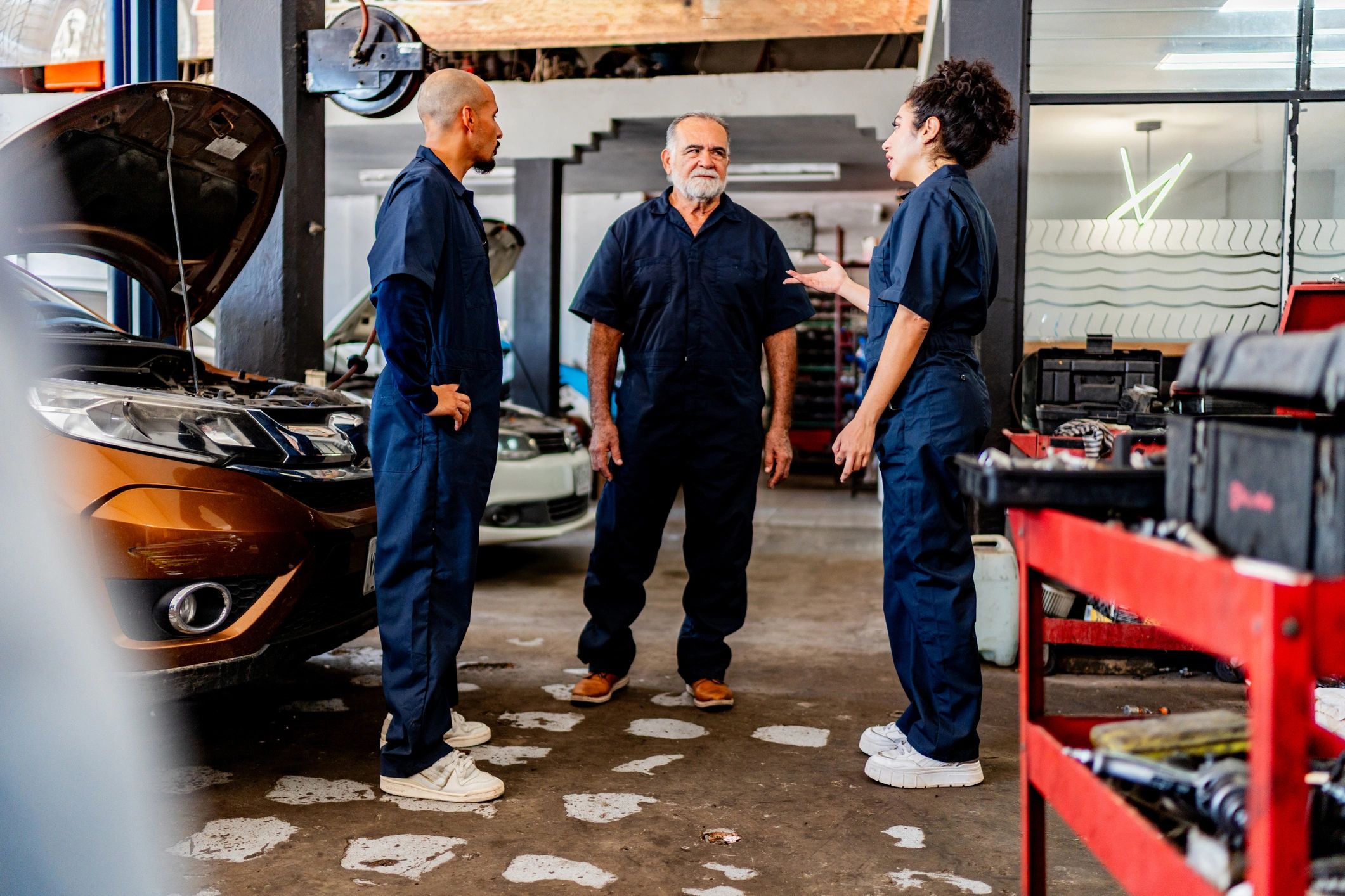 Mechanics discussing a repair plan in the shop